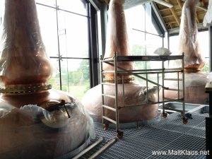 The stills at Lindores Abbey distillery overlooking the abbey's ruins